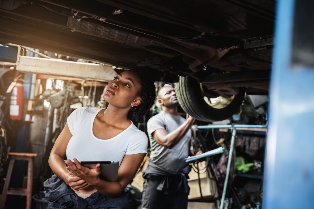 Portrait of the mechanic checklist the parts around the car