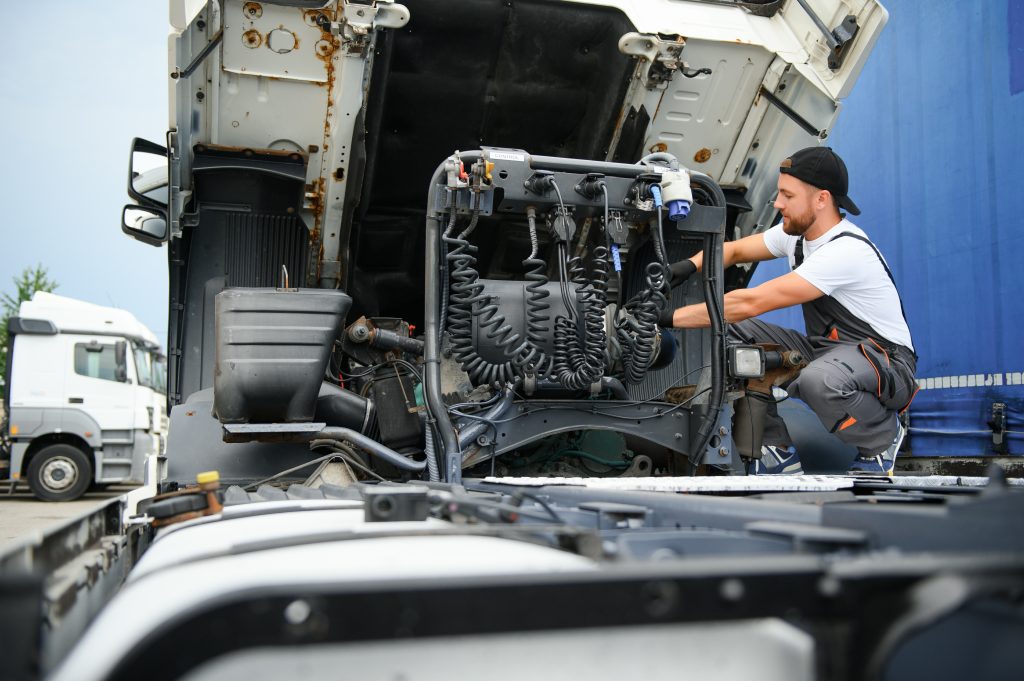 Technician performing AC repair on a commercial truck